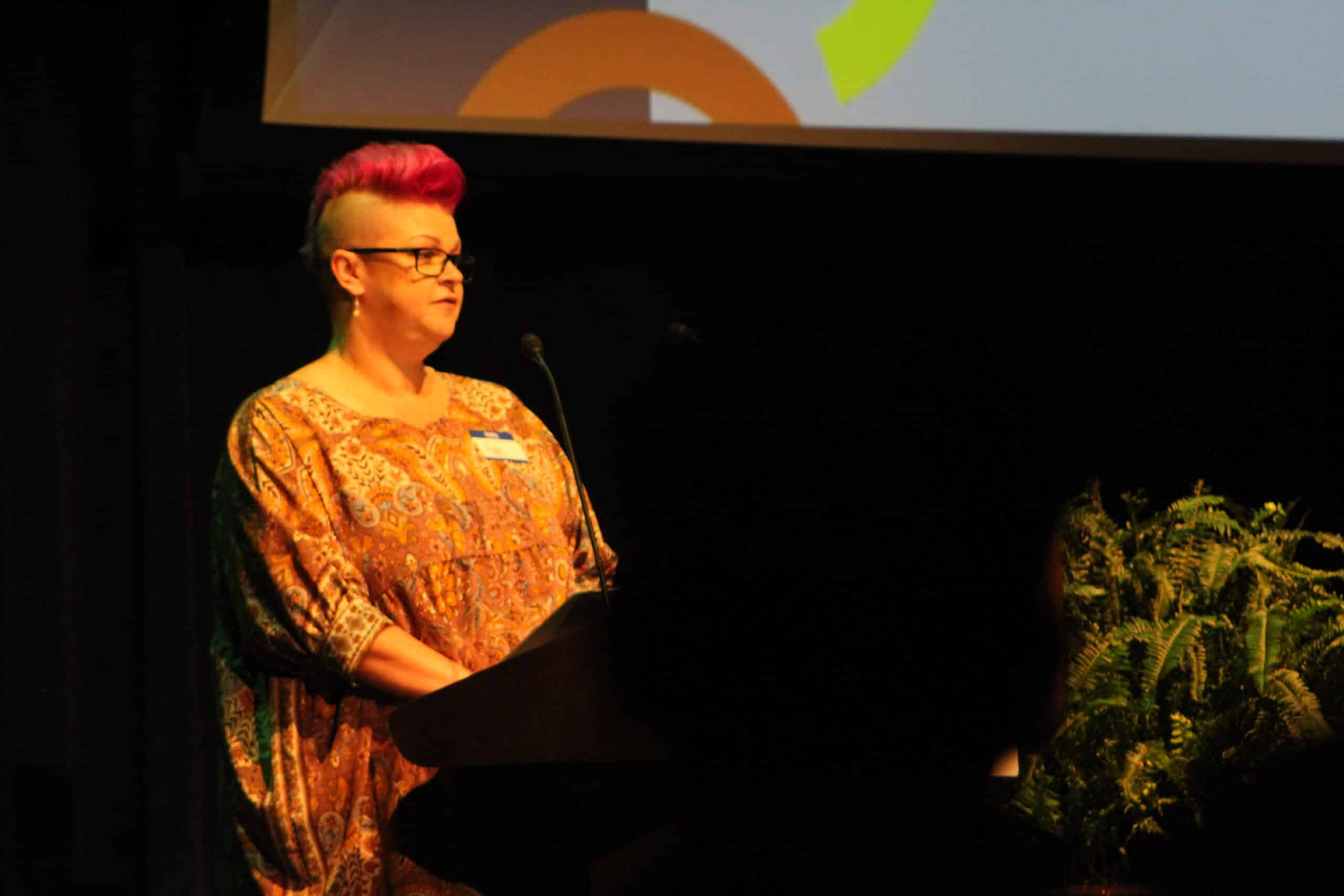Kate DePoole shares her story at podium